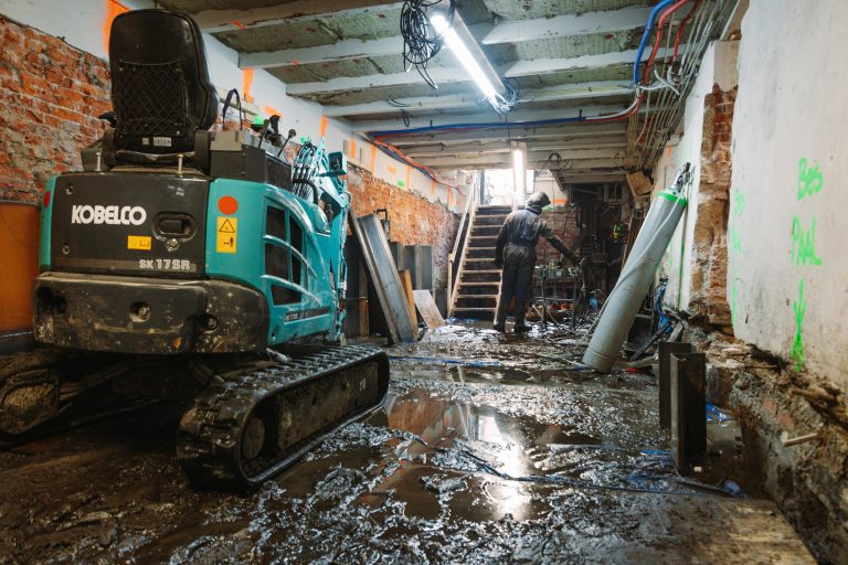 Een graafmachine helpt bij het uitgraven van een kelder in Amsterdam - Bouwcon