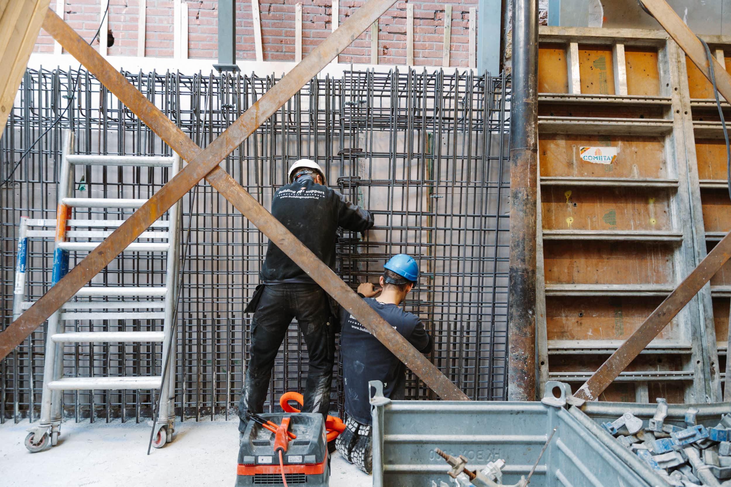 Twee bouwvakkers werken aan de wapening voor een nieuwe fundering