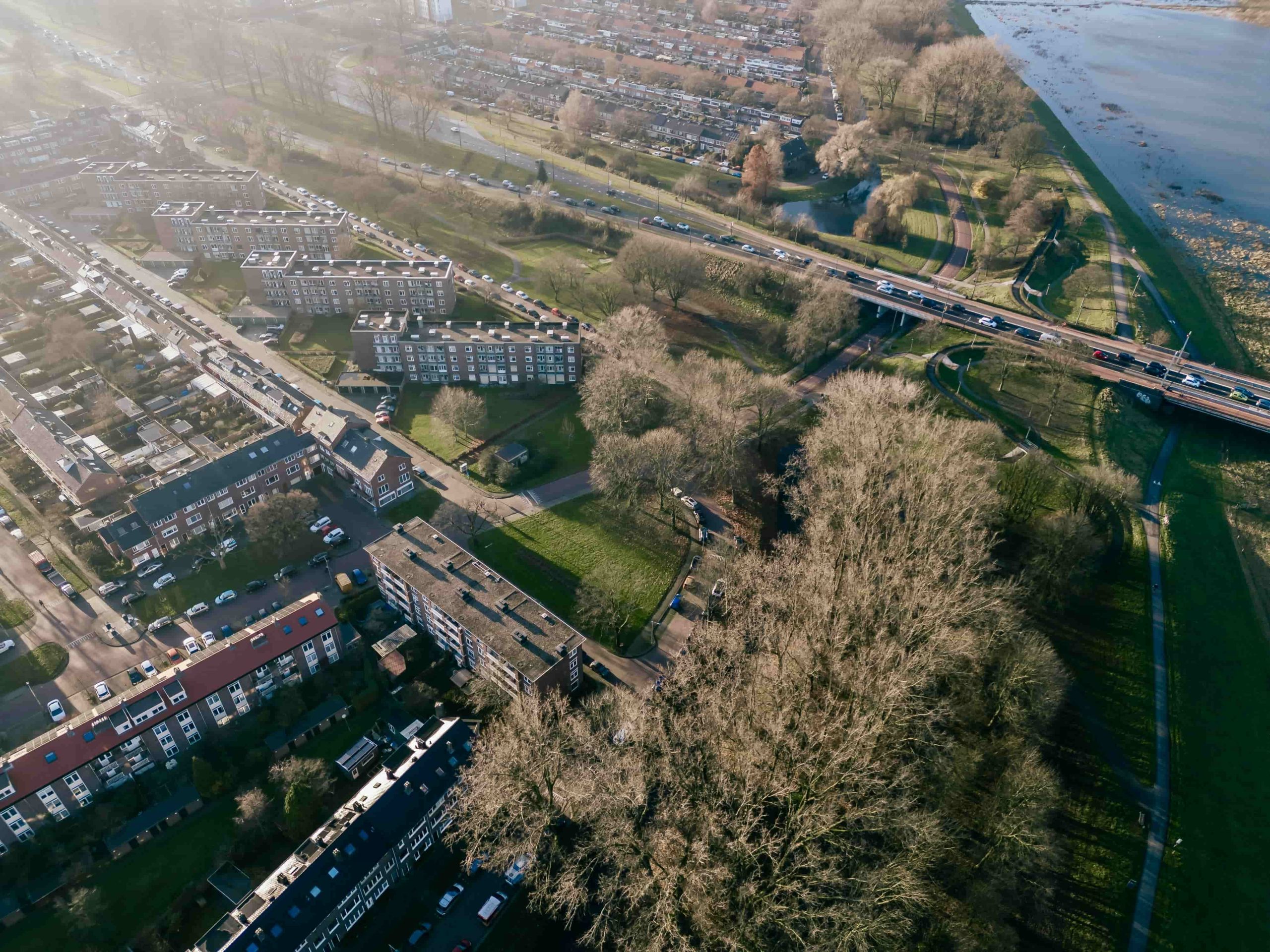 Luchtfoto van een woonwijk met flats en rijtjeshuizen langs de Rijn in Arnhem